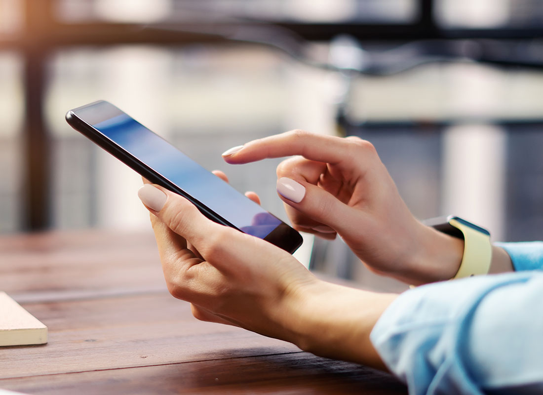 Request Policy Change - Woman Using an iPhone to Request a Policy Change on Her Insurance Policy